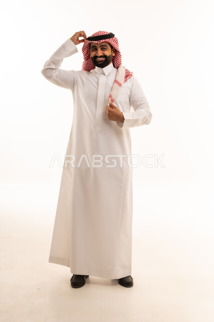 رجل سعودي بالثوب الأبيض يعدل الشماغ على خلفية بيضاء