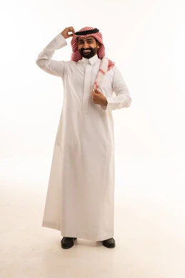 رجل سعودي بالثوب الأبيض يعدل الشماغ على خلفية بيضاء
