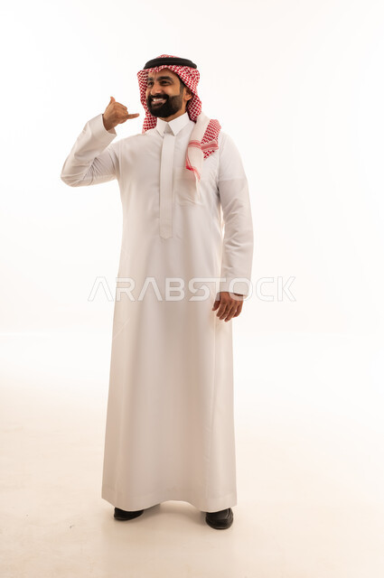 رجل سعودي يقوم بإيماءة اتصل بي باليد بالزي التقليدي
