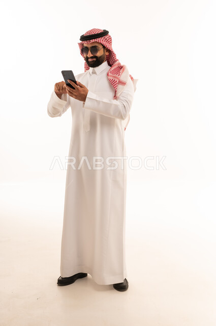 Saudi Man in Thobe Using Smartphone on White Background