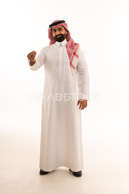رجل سعودي بالزي التقليدي يقوم بإيماءة يد