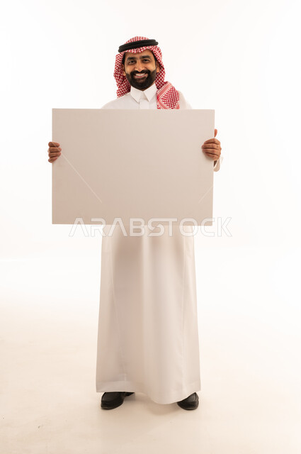 Saudi Man in Traditional Dress Holding Blank White Board