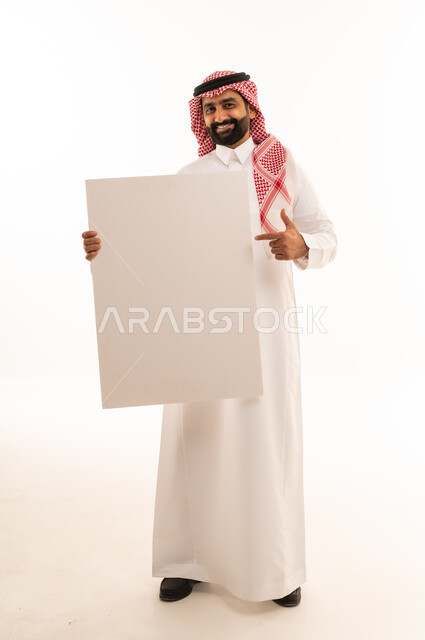 رجل سعودي يمسك لوحة بيضاء فارغة للدعاية والإعلان