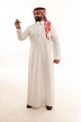رجل سعودي يكتب بالقلم أمام خلفية بيضاء داخل استوديو
