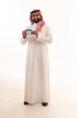 رجل سعودي يحمل بطاقة تعريفية فارغة على خلفية بيضاء