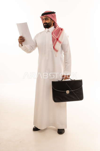 رجل أعمال سعودي يحمل حقيبة عمل ومستند