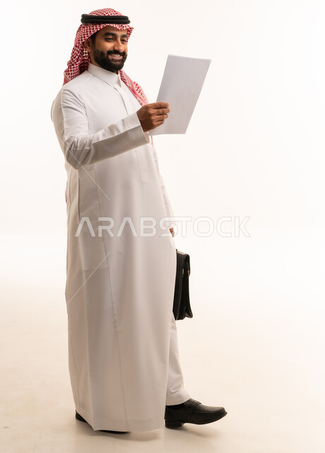 رجل أعمال سعودي يحمل وثيقة وحقيبة أعمال