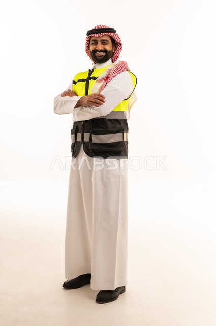 مهندس سعودي يرتدي سترة السلامة والزي التقليدي