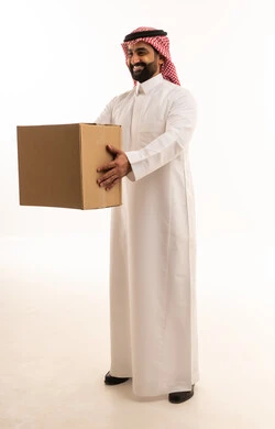 رجل سعودي يحمل صندوق شحن كرتوني بخلفية بيضاء