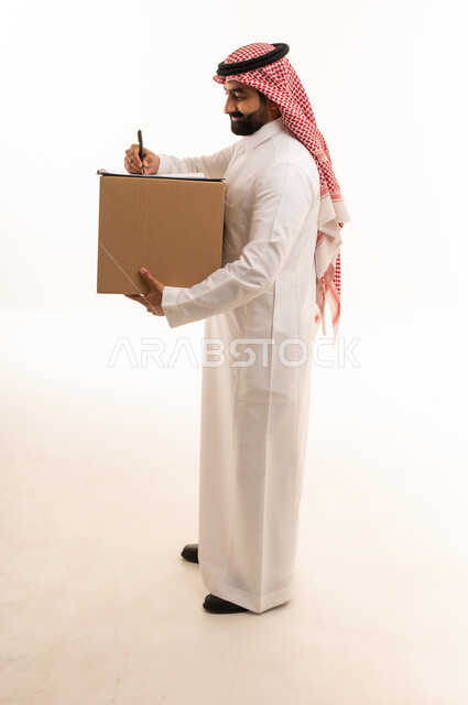 رجل سعودي يحمل صندوق توصيل ويكتب على لوحة ملاحظات