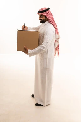 رجل سعودي يحمل صندوق توصيل ويكتب على لوحة ملاحظات