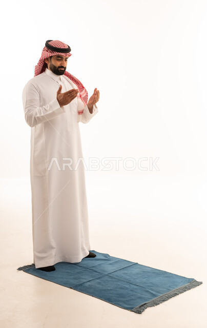 Saudi Man Praying on Rug with White Background