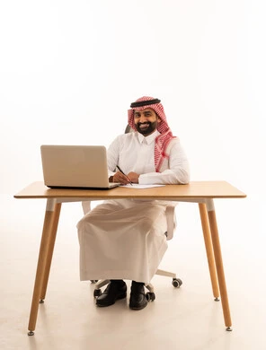 Saudi Businessman Working at Desk with Laptop