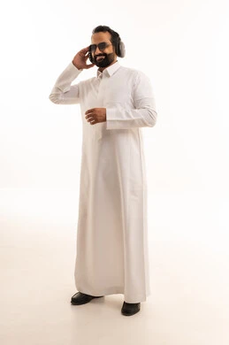 Saudi Man in White Thobe Wearing Headphones