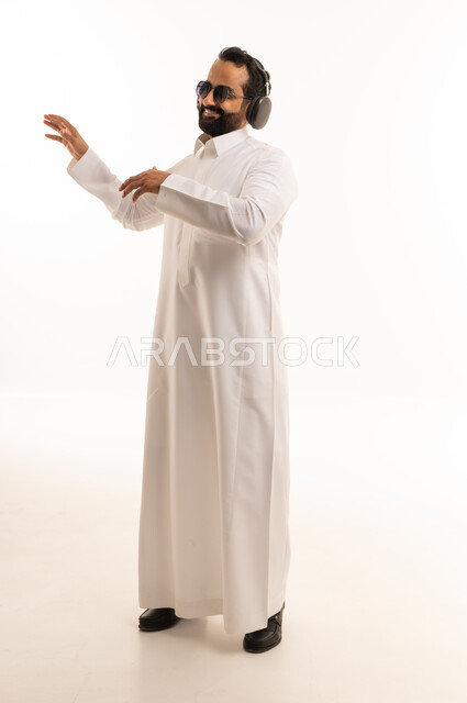 رجل سعودي بالثوب يستمع للموسيقى بالسماعات