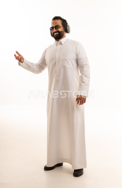 رجل سعودي بالثوب وسماعات الرأس خلفية بيضاء