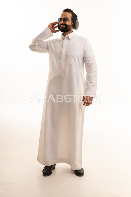 رجل سعودي بالثوب الأبيض يرتدي سماعات رأس