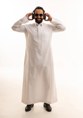 رجل سعودي بالثوب التقليدي يرتدي سماعات رأس ونظارات