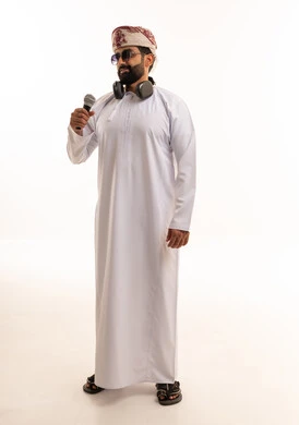 رجل عُماني باللباس التقليدي يحمل ميكروفون