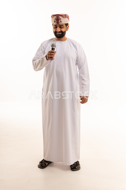 رجل عماني بالزي التقليدي يمسك ميكروفون