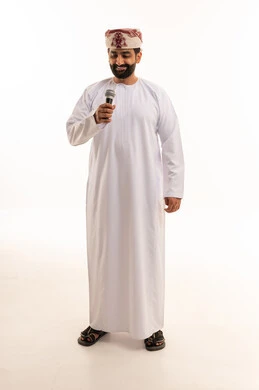 رجل عماني بالزي التقليدي يمسك ميكروفون