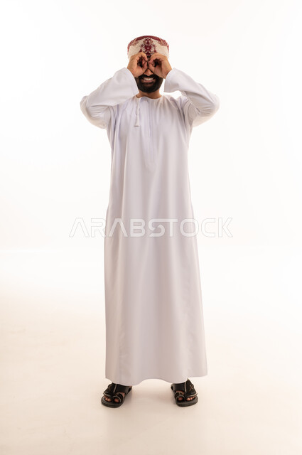 رجل عماني بالزي التقليدي يقوم بإيماءة المنظار