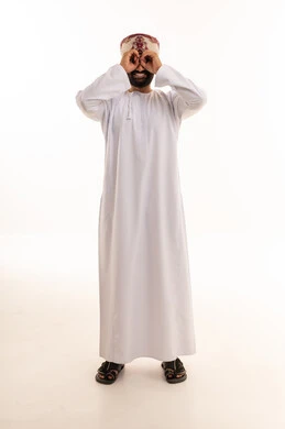 رجل عماني بالزي التقليدي يقوم بإيماءة المنظار