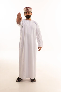 رجل عماني بالزي التقليدي يشير بعلامة التوقف