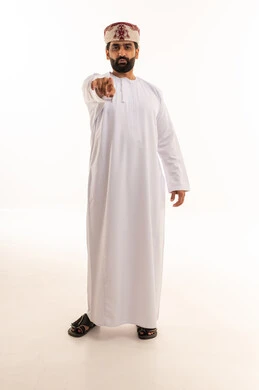 رجل عماني بالزي التقليدي يشير نحو الكاميرا