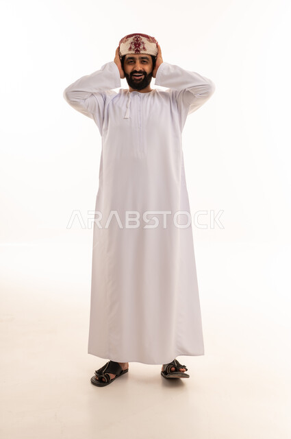 رجل عماني مندهش يغطي أذنيه بالزي التقليدي