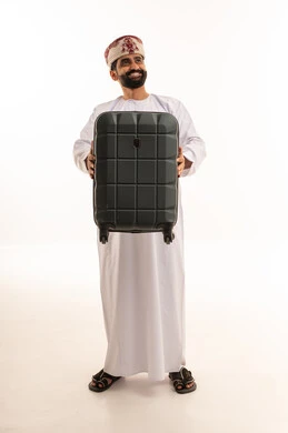 رجل عماني بالزي التقليدي يحمل حقيبة سفر رجل عماني بالزي التقليدي يحمل حقيبة سفر