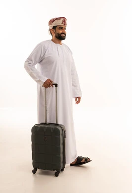 رجل عماني بالزي التقليدي مع حقيبة سفر