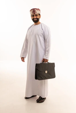 رجل أعمال عماني بالزي التقليدي يحمل حقيبة عمل