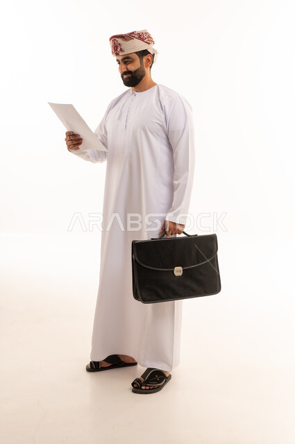 رجل أعمال عماني يحمل حقيبة عمل ومستندات