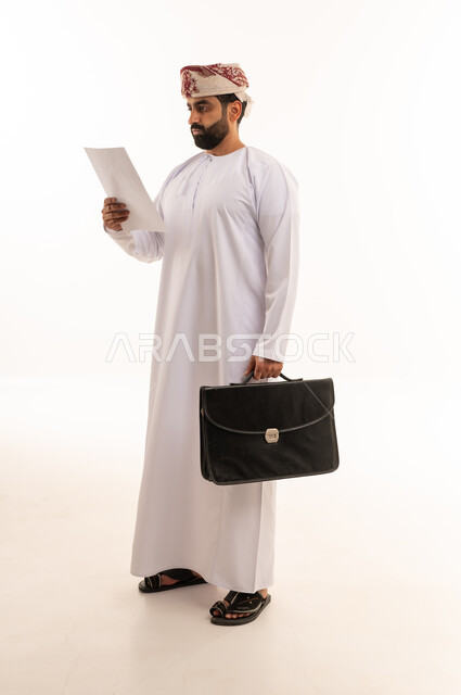 Omani Businessman Reading Document with Briefcase