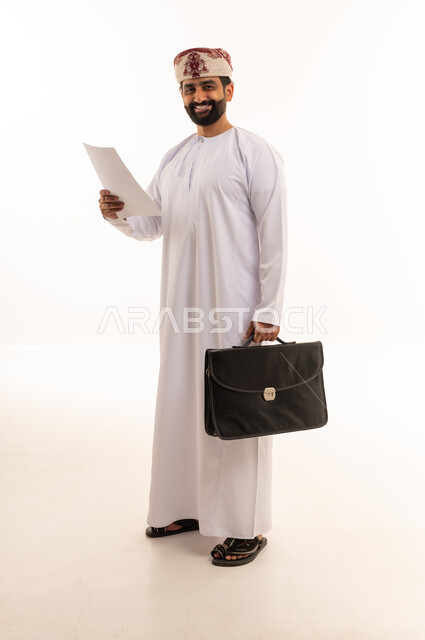 رجل أعمال عماني بالزي التقليدي يحمل حقيبة