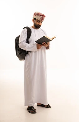 رجل عماني بالزي التقليدي يقرأ كتاباً
