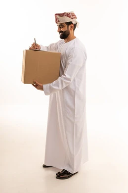 رجل عماني يوقع على صندوق شحن بخلفية بيضاء