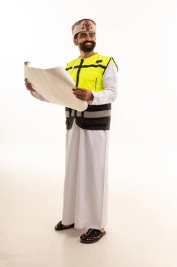 مهندس عماني يمسك مخططات هندسية بزي السلامة
