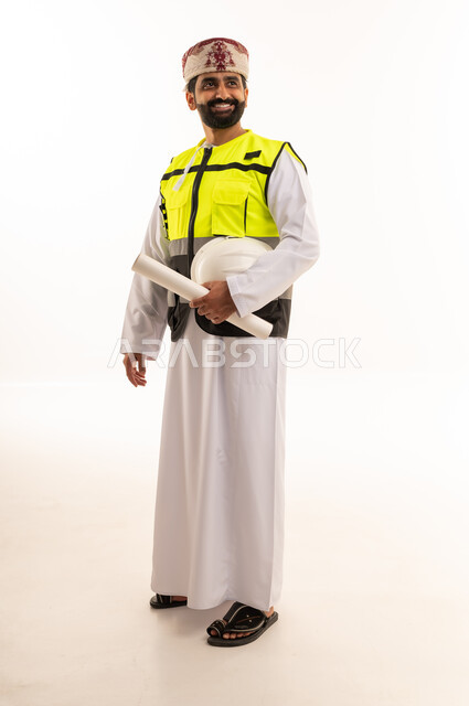 Omani Engineer in Traditional Dress with Blueprints