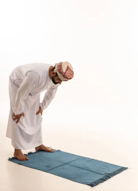 Omani Man in Traditional Dress Praying on Mat