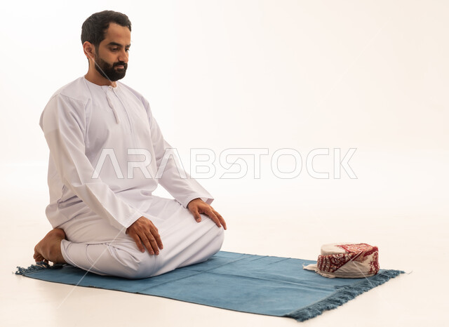رجل عماني يصلي بالدشداشة التقليدية والكمة