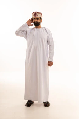 رجل عماني بالدشداشة التقليدية يقوم بإيماءة الاستماع
