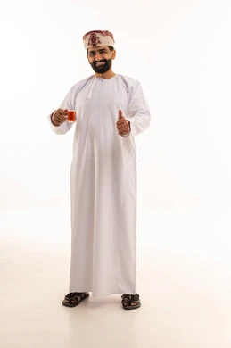رجل عماني بالزي التقليدي يرفع علامة الإبهام