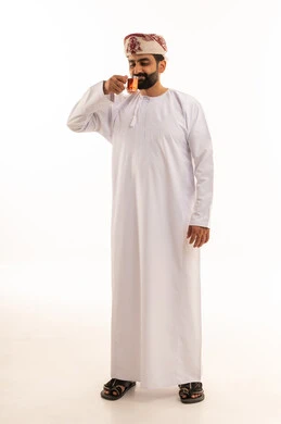 Omani Man in Traditional Dress Drinking Tea on White