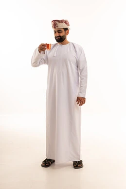 Omani Man in Traditional Dishdasha Holding Tea