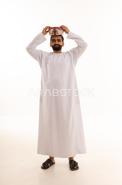 رجل عماني بالدشداشة والكمة التقليدية على خلفية بيضاء