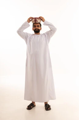 رجل عماني بالدشداشة والكمة التقليدية على خلفية بيضاء