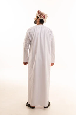 رجل عُماني بالزي التقليدي والمصر من الخلف