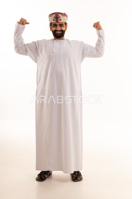 رجل عماني بالزي التقليدي يستعرض عضلاته